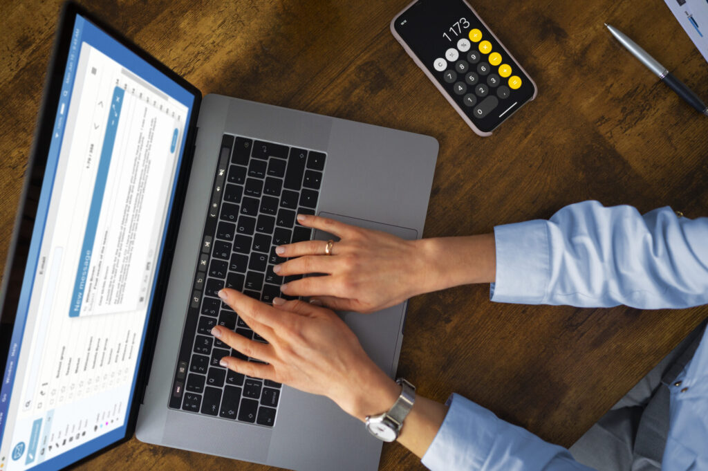 mãos de uma pessoa digitando em um laptop